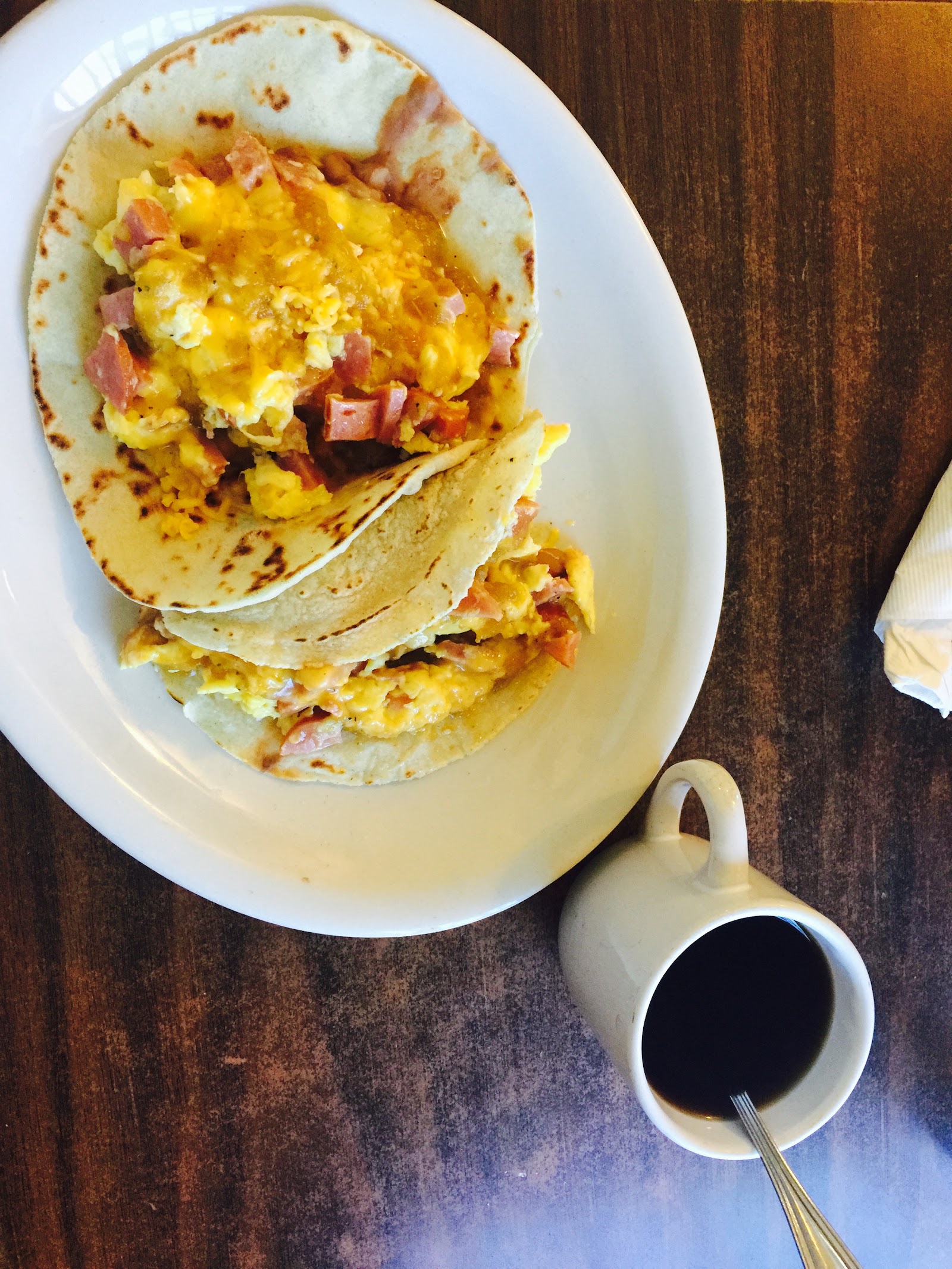 Ham and egg breakfast tacos served with a cup of coffee